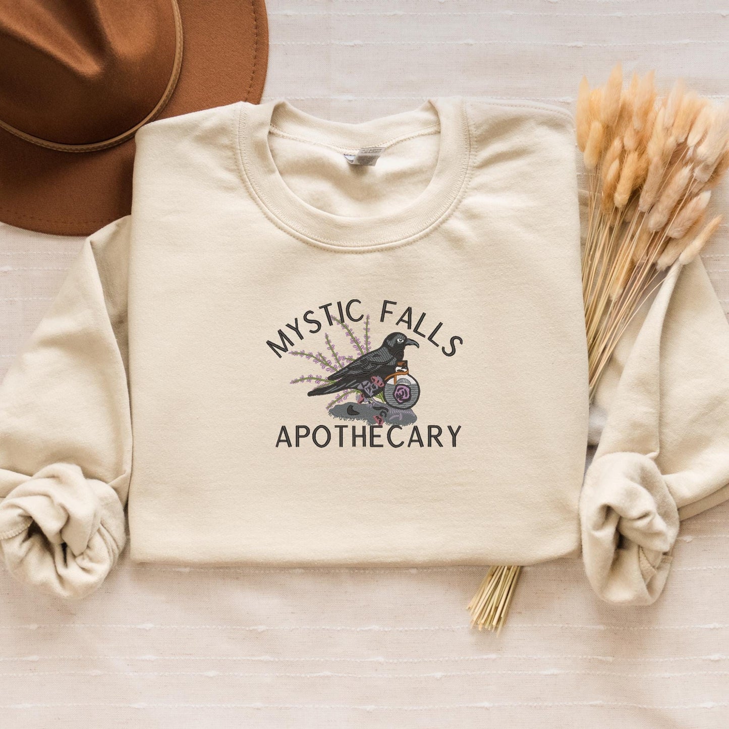 a white sweatshirt with the words mystic falls apothecary on it