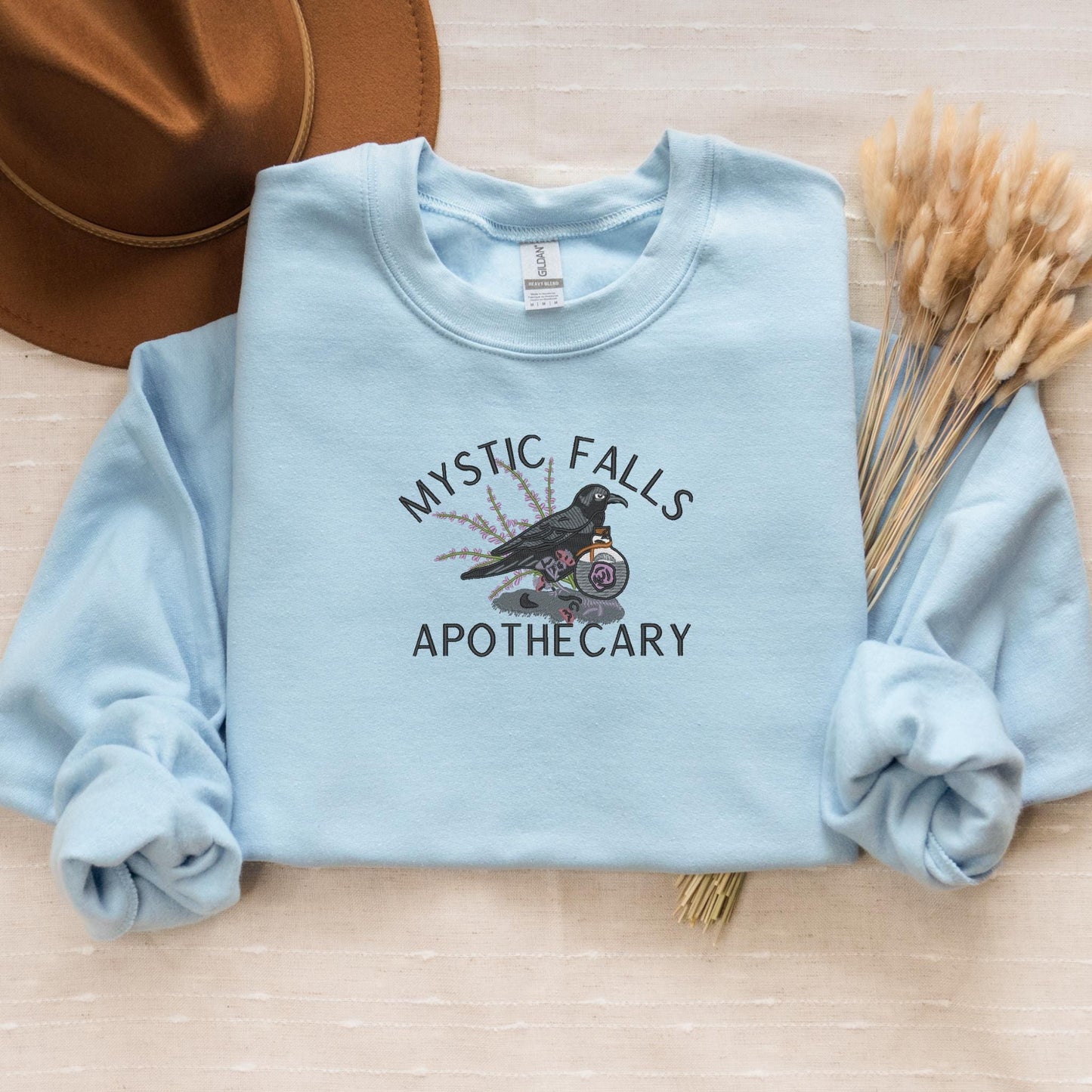 a blue shirt with a bird on it and a hat