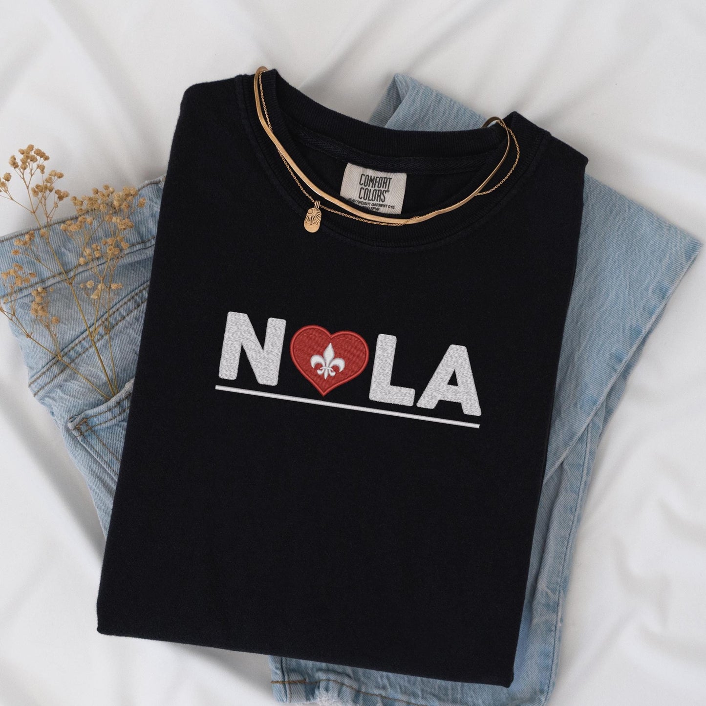 a black t - shirt with a heart and fleur de l'oeu