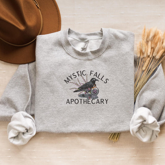 a sweater with a bird on it and a hat next to it