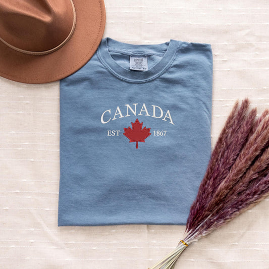 a hat, t - shirt, and dried grass on a bed