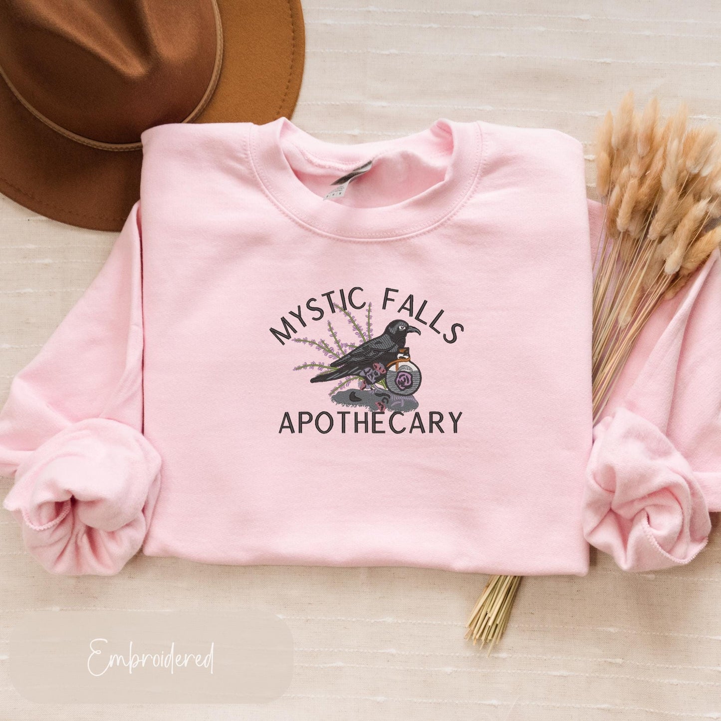 a pink sweatshirt with a black bird on it