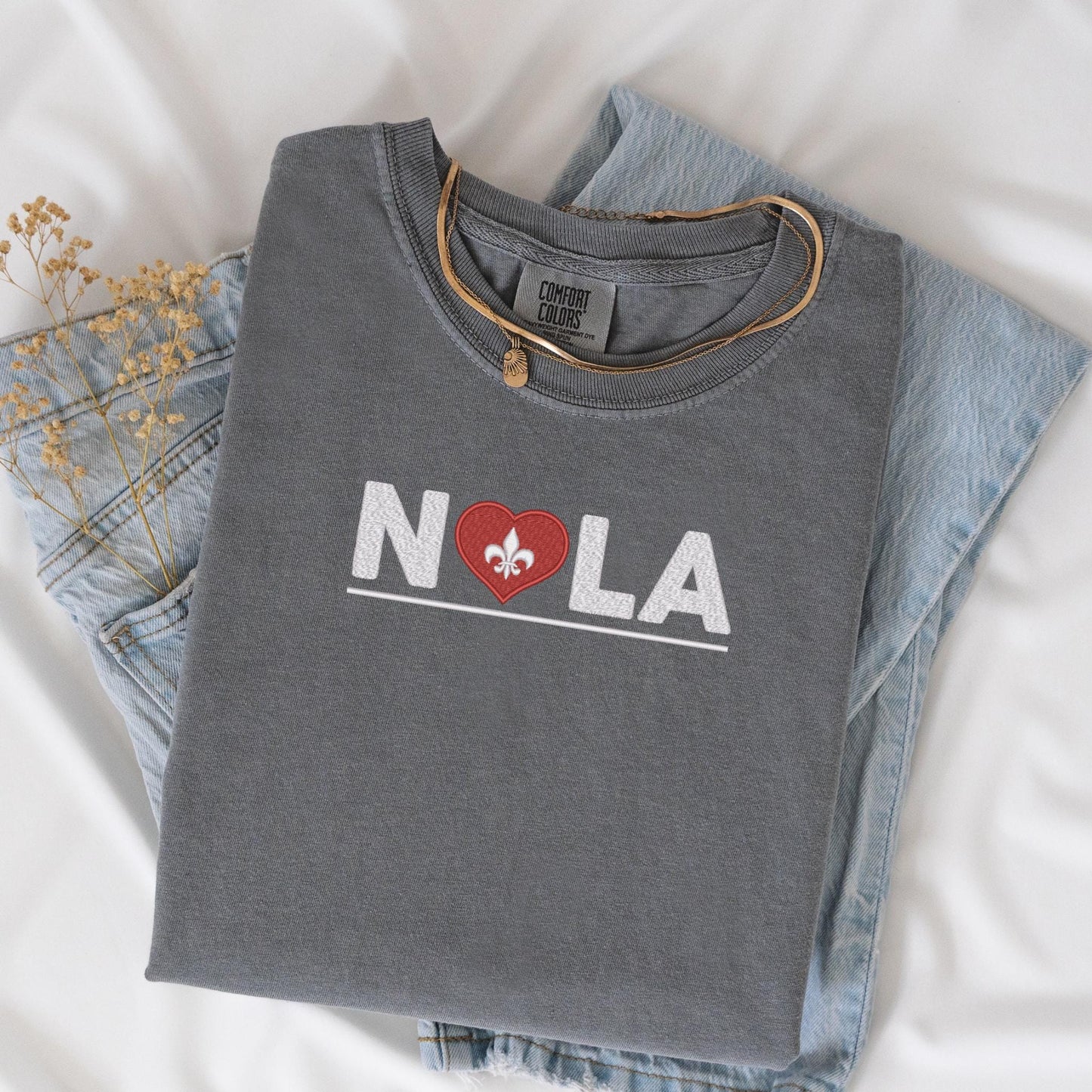 a pair of jeans and a t - shirt with the word nola on it