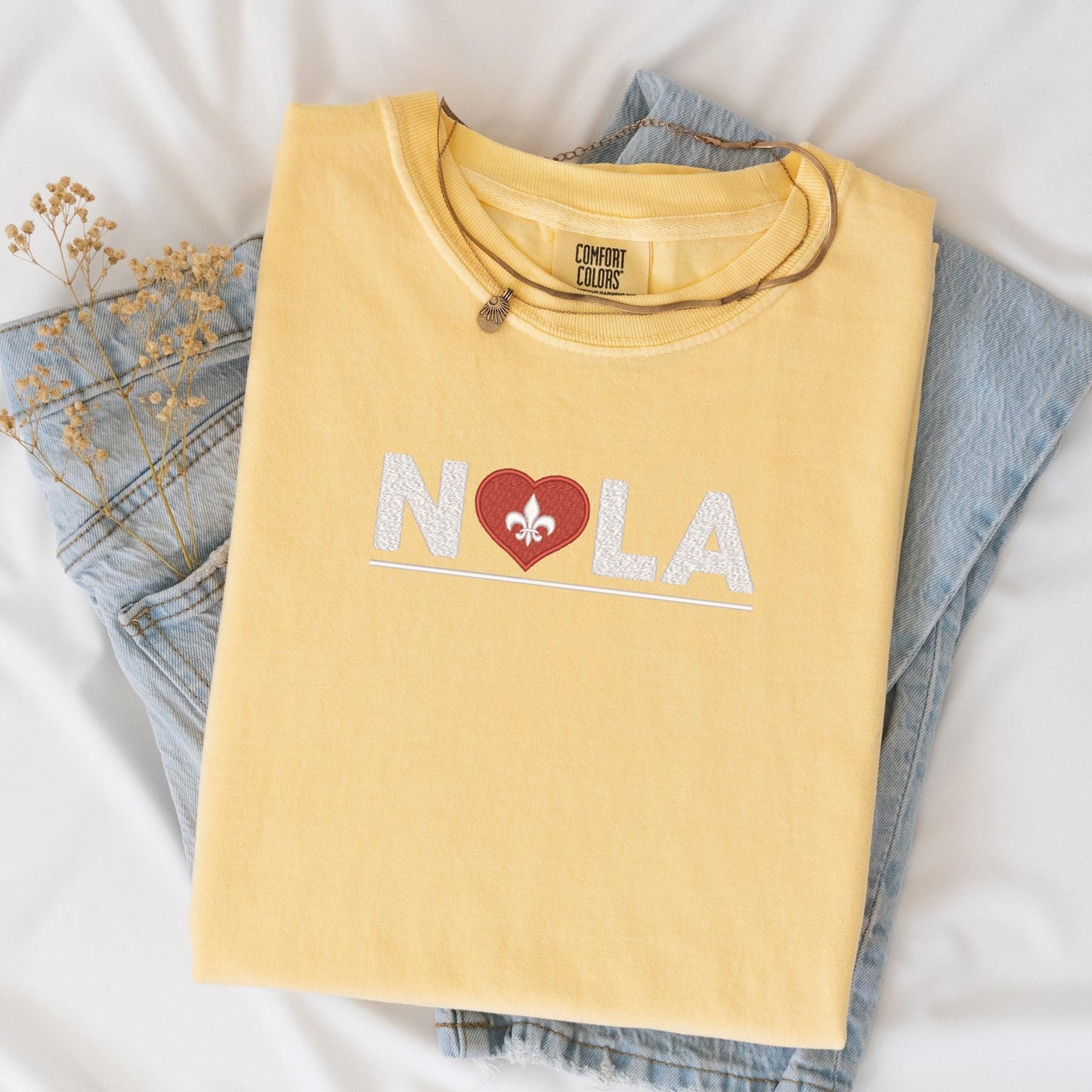 a pair of jeans and a t - shirt with the word nola on it