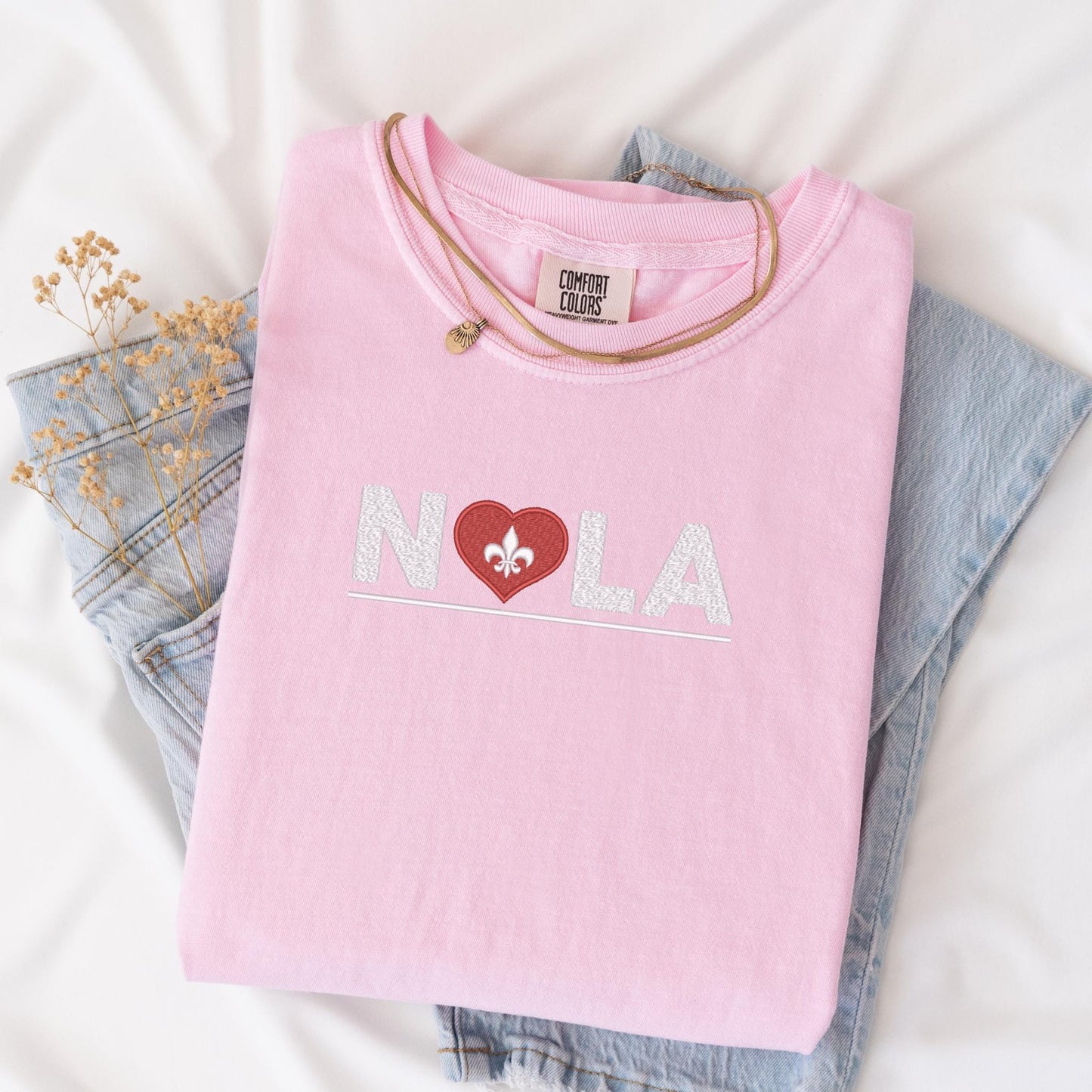 a pink shirt with a heart and a bow on it